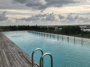 金宝Netflix l Chill Studio Kampar Champs Élysées的一座带蓝色水和金属栏杆的大型游泳池
