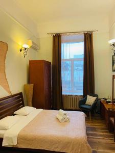 基辅基辅中心纯真家园公寓的一间卧室配有一张床、一张书桌和一个窗户。