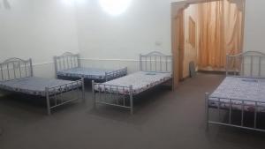 拉合尔Residency Girls Hostel - For Females Only的一间客房内的四张床