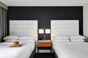 坦帕Hotel Tampa Riverwalk的两张睡床彼此相邻,位于一个房间里