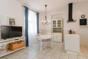 希洛Pavi apartments Vila Amalia的厨房以及带桌子和电视的用餐室。