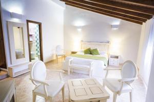 扎霍拉AROHAZ Hotel & Restaurante的卧室配有白色家具和1张床及椅子