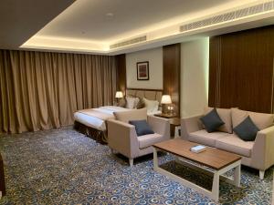 哈萨فندق ضيافة القرية Al Diyafa Hotel的配有床、椅子和桌子的酒店客房