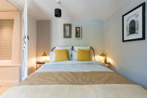 赛伦塞斯特Talliers Cottage - Characterful & Central的一间卧室配有一张带黄色枕头的大床
