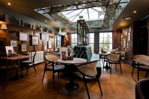 鲍内斯温德米尔The Angel Inn - The Inn Collection Group的餐厅设有桌椅和窗户。