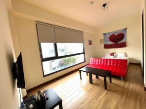 花莲市花莲二街窝窝电梯民宿的客厅设有红色的沙发和窗户。