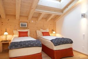采尔马特Matterhorn Lodge Boutique Hotel & Apartments的木墙客房的两张床