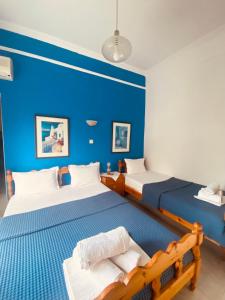 斯卡拉卡里拉奇斯Garden Guesthouse的一间卧室设有两张带蓝色墙壁的床