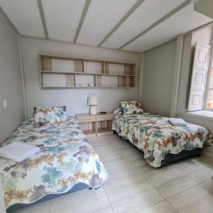 拉塞雷纳Casa Hostal Paso por La Serena的一间卧室设有两张床和窗户。