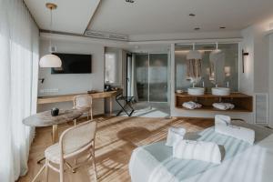 特拉萨Hotel Petit Luxe的卧室配有一张床和一张桌子及椅子