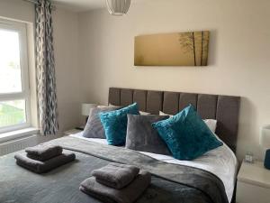 卡诺斯蒂Beautiful 2 bedroom flat overlooking golf course的一间卧室配有一张带蓝色枕头的大床