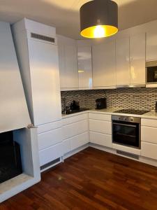 奥斯陆Oslo City Apartment的厨房配有白色橱柜和炉灶烤箱。