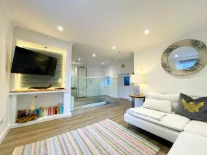 昆斯费里Stunning Loft Apartment South Queensferry High St Bridge Views!的客厅配有白色沙发和镜子