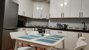 白采尔科维Запорізька 19. City Rooms的厨房配有白色橱柜和桌椅
