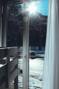 VicdessosEau Berges - Chez Mamie的阳光透过雪面闪烁的窗户