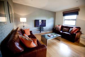 切姆切姆斯福德服务式公寓酒店的客厅配有两张沙发和一台电视机
