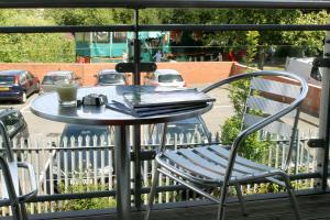 切姆切姆斯福德服务式公寓酒店的阳台上的桌椅,边喝咖啡边休息