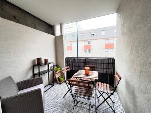 克莱蒙费朗Le Verrières - Appartement Cozy avec balcon proche de la gare的一个带桌椅的阳台和一座建筑