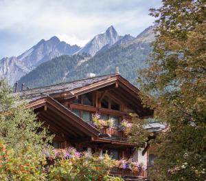 采尔马特Matterhorn Lodge Boutique Hotel & Apartments的带阳台的度假屋,享有山脉背景