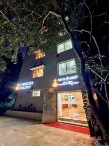 班加罗尔Sai Shreyas Residency, Best Hotel near Bangalore Airport的夜间在建筑物前的商店