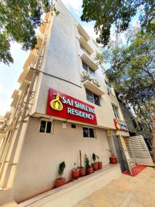 班加罗尔Sai Shreyas Residency, Best Hotel near Bangalore Airport的植物建筑的一侧的标志