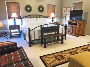 BurtonInn at Indian Creek的一间卧室配有一张床、一台电视和一张沙发