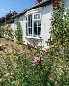 WhittleseyField Cottage的一座房子,前面有一个种着鲜花的花园