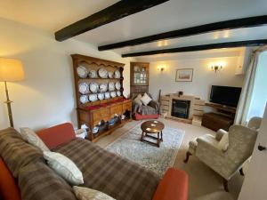 克里克豪厄尔Scenic Welsh Cottage in the Brecon Beacons的带沙发和壁炉的客厅