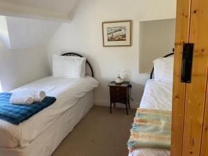 克里克豪厄尔Scenic Welsh Cottage in the Brecon Beacons的一间卧室配有两张床和一张桌子及床头柜