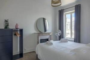 奥尔良T2 Le Châtelet的白色卧室设有一张大床和镜子