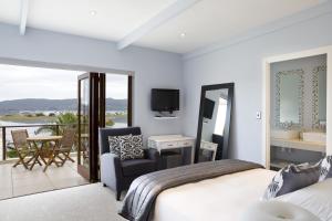 克尼斯纳Tides End Manor House的一间卧室设有一张床,阳台配有电视。