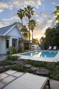 克尼斯纳Tides End Manor House的一座带游泳池和棕榈树的房子