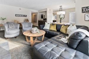 蓝山Blue Mountain Chalet Condo with Amazing Location的客厅配有黑色真皮沙发和桌子