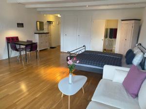 NidauJoline private guest apartement Studio 45m2的客厅配有床和鲜花桌