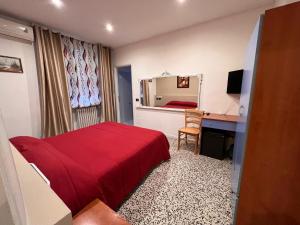维杰瓦诺Hotel Saratoga的一间卧室配有红色的床、一张书桌和镜子