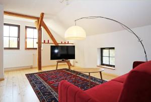 马尔欣Naturerlebnis的客厅配有红色沙发和电视