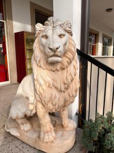 维杰瓦诺Hotel Saratoga的狮子雕像在建筑物前