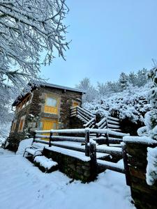 SarreausAldea Couso Rural的雪中带长凳的房子