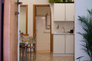 卡塔尼亚La Casetta的厨房配有白色橱柜和桌椅