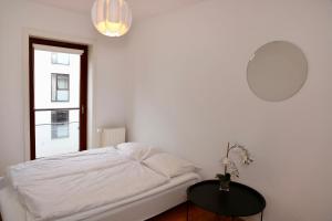 哥本哈根Scandi-Hygge 2 bedroom apartment in charming Christianshavn的白色卧室配有床和桌子