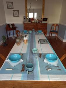 索米尔La douceur Saumuroise avec petit déjeuner的一张桌子上放着蓝色碗和餐具
