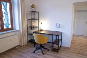 开姆尼茨Business-Apartment - Citynah, WLAN, Drucker, Netflix & Parken的办公室,带桌子和黄椅