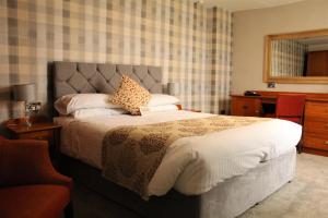 斯卡伯勒橡木轮宾馆的一间卧室配有一张大床和一张书桌