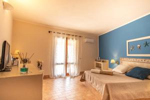 兰佩杜萨瑞丽斯艾素德尔萨德酒店的一间卧室设有蓝色的墙壁、一张床和电视。