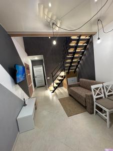 乌曼岛Апартаменты Well - Being的带沙发和楼梯的客厅