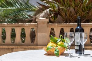 科洛尼亚圣霍尔迪M0 Práctico y Sencillo Apartamento a 100 m de las mejores playas de Mallorca的一张桌子,上面放着一瓶葡萄酒和两杯酒