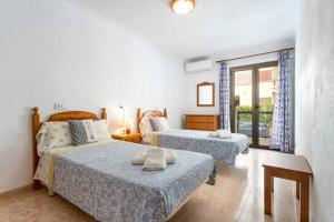 科洛尼亚圣霍尔迪M0 Práctico y Sencillo Apartamento a 100 m de las mejores playas de Mallorca的一间带两张床的卧室和一个阳台