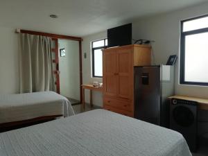 瓜纳华托Casa Caracol Guanajuato的酒店客房配有两张床和一台冰箱