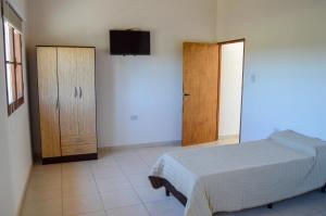 卡法亚特La Justina - Alquiler Temporario的一间卧室配有一张床、一个橱柜和一台电视