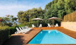 卢米奥Mobilhomme LECCI 3 CHAMBRES AVEC VUE MER EXCEPTIONNELLE的一个带躺椅和遮阳伞的游泳池